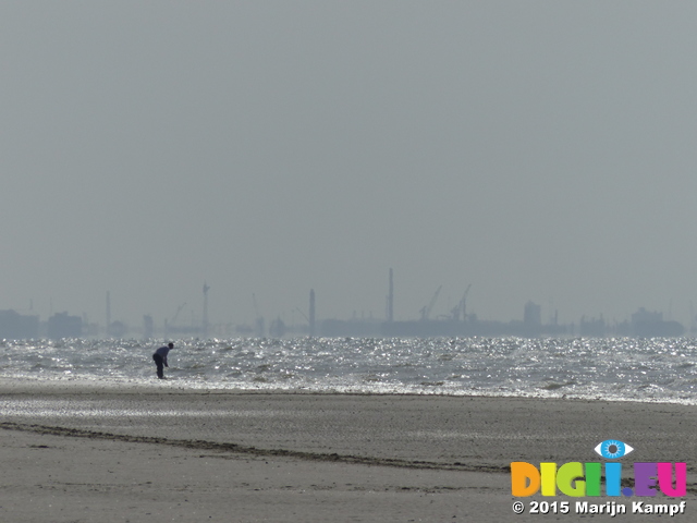 FZ015981 Man on beach with heavy industry in background